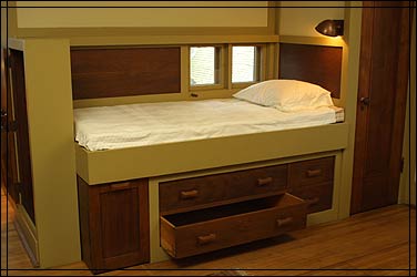 Built-in chest of drawers beneath bed provides additional storage space